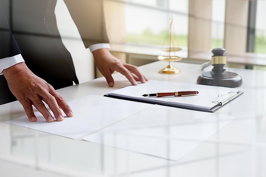 lawyer standing at desk with paperwork gavel and scales bellmore ny